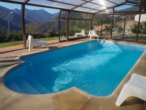 Piscina climatizada interior con vistas a la montaña en Casa Rural Posada Real de Pajares, España. Tumbonas y cerramiento de cristal