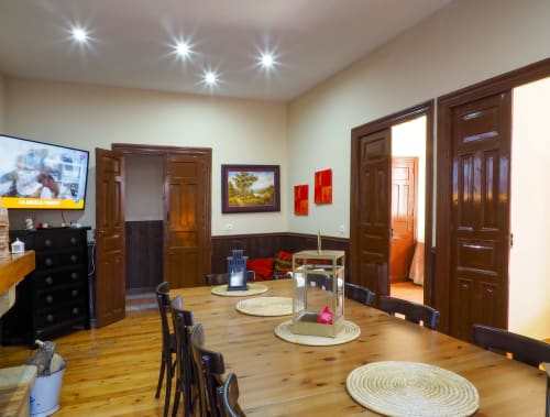 Espacioso comedor de Casa Rural Posada Real en Pajares con piso de madera, manteles redondos, puertas de madera oscura, TV y
