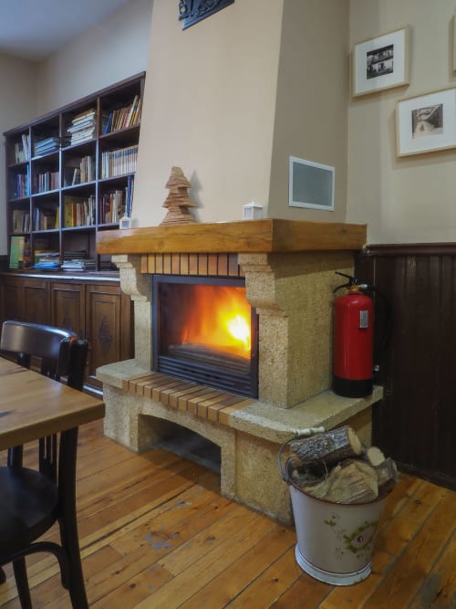 Chimenea moderna con fuego resplandeciente en la sala de estar rústica de Casa Rural Posada Real de Pajares, España