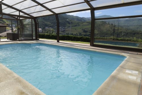 Piscina climatizada cubierta con vistas al valle de montaña en Casa Rural Posada Real de Pajares, Asturias