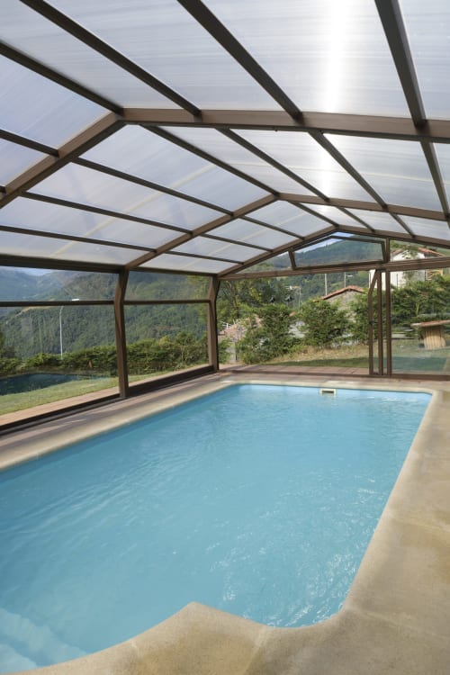 Piscina climatizada cubierta con techo de policarbonato con vistas a las montañas en Casa Rural Posada Real de Pajares, España
