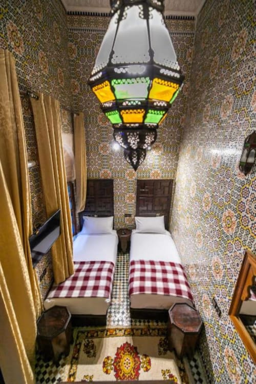 Chambre twin deluxe du Riad Fes Aicha avec carrelage zellige raffiné, lanterne décorative et décoration traditionnelle marocaine à Fès