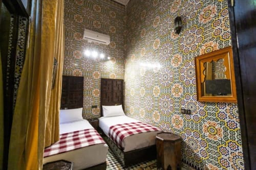 Chambre twin aux murs décorés de zellige marocain ornementé au Riad Fès Aïcha à Fès