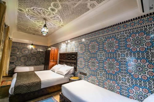 Chambre traditionnelle du riad marocain au Riad Fes Aicha à Fès, avec zellige ornementé, plafond travaillé et lits jumeaux