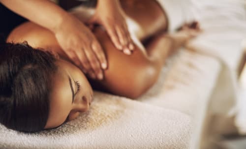 Femme recevant un massage relaxant du dos au spa Riad Fes Aicha à Fès, Maroc