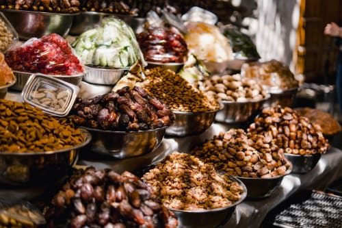 Marché aux épices du Riad Fes Aicha : dattes séchées, fruits secs et épices marocaines colorées en coupes