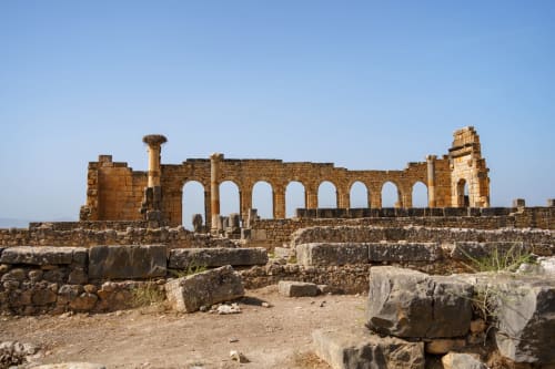 Ruines romaines antiques avec colonnade voûtée à Volubilis, site du patrimoine près de Fès, Maroc