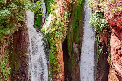 Murs en pierre couverts de mousse avec cascade d'eau à l'hôtel Le Cèdre D'argent à Fès, Maroc