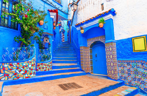 Cour bleue éclatante de l'hôtel Le Cèdre d'Argent à Fès avec ses carrelages marocains colorés et son architecture traditionnelle