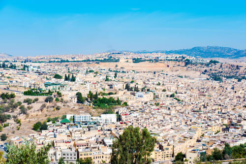 Vue aérienne de la médina de Fès avec architecture traditionnelle, cyprès et localisation de l'hôtel Le Cèdre D'argent