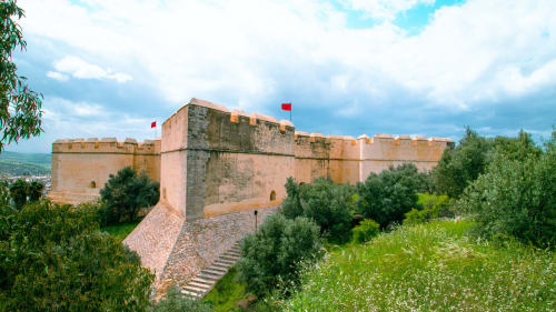 Ancienne kasbah fortifiée aux murs en terre cuite et drapeaux rouges dominant Fès, Maroc, près du Riad Fes Aicha