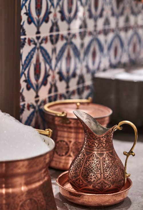 Pichet en cuivre ouvragé avec poignée en laiton et plaque décorée au Riad Fes Aicha à Fès, Maroc