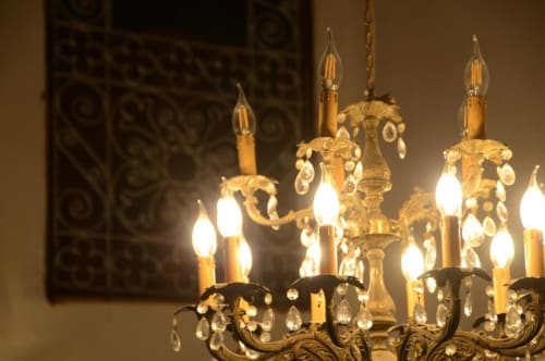 Lustre en cristal orné avec ampoules style bougies dans une chambre de l'hôtel Le Cèdre d'Argent, Fès