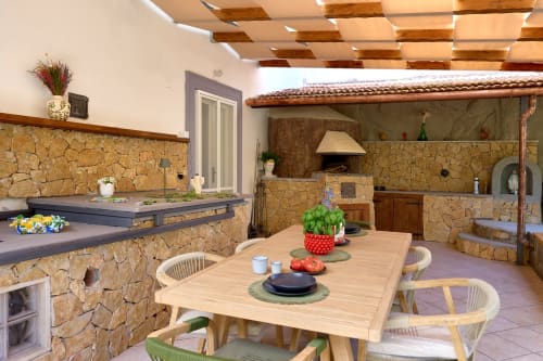 Lemon Garden Escape villa at Sorrento Sea View features stone outdoor dining area with wooden table, chairs, and full kitchen
