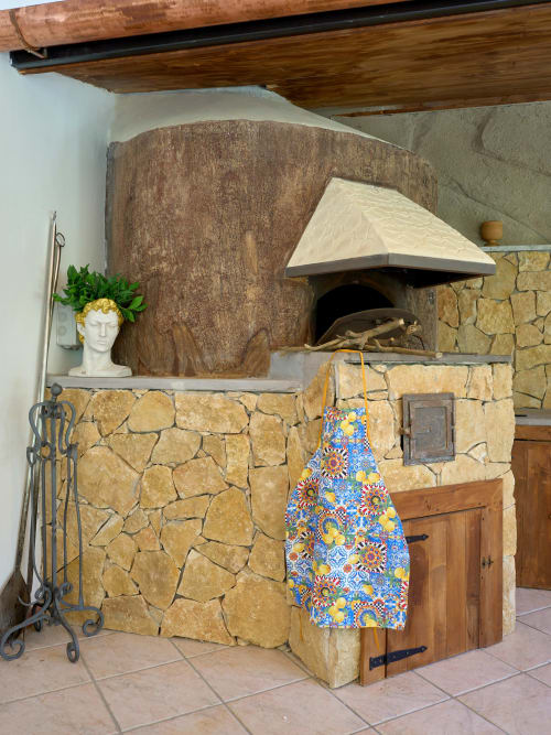 Stone wood-fired oven in garden villa at Sorrento Sea View with decorative apron and fireplace tools