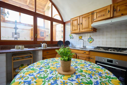 Bright kitchen in The Lemon Garden Escape villa at Sorrento Sea View, featuring colorful lemon-patterned table, wooden