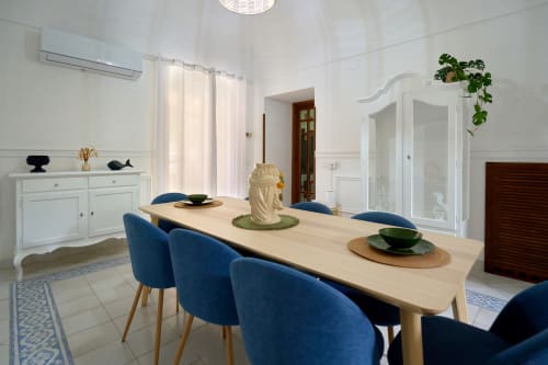 Bright dining room at Sorrento Sea View villa with natural wood table, blue chairs, and white cabinetry in Piano di Sorrento