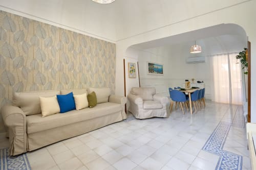 Modern villa living room with cream sofa, blue accents, and dining area at Sorrento Sea View, Piano di Sorrento