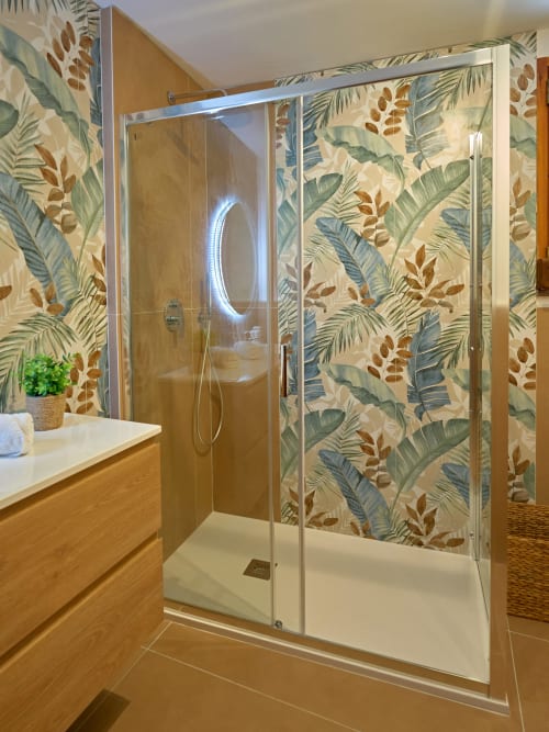 Modern shower enclosure in The Lemon Garden Escape villa at Sorrento Sea View with tropical botanical wallpaper and wooden