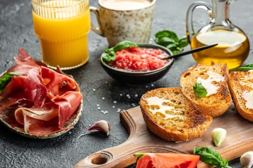 Desayuno español en Hotel Boutique Zahara con jamón ibérico, pan tostado, tomate triturado, zumo de naranja y aceituna