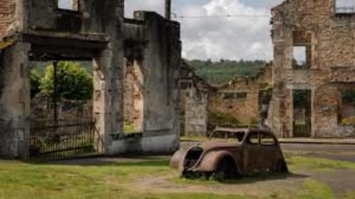 Voiture rouillée abandonnée devant les ruines historiques en pierre du Domaine de Châlus-Chabrol, un gîte de charme en campagne