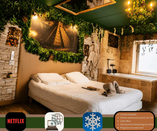 Chambre luxe romantique avec lit king, dais de plantes vertes, éclairage chaleureux, murs en pierre et équipements modernes à L'expérience Love