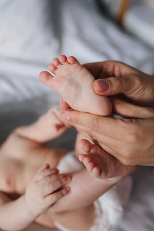Newborn baby's foot held by adult hands at Maison Monsieur Léger in Montaut
