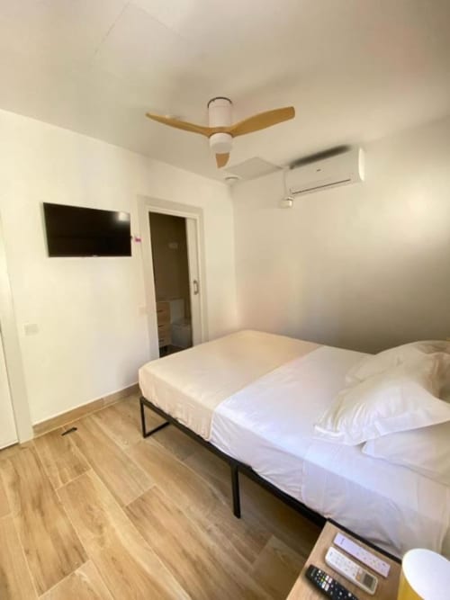 Habitación moderna en Grampy Boutique Hostal con cama doble, TV de pantalla plana, ventilador de techo y aire acondicionado