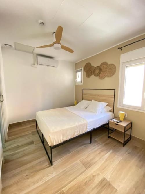 Habitación moderna en Grampy Boutique Hostal con cama matrimonial, cabecero de madera, ventilador de techo y luz natural