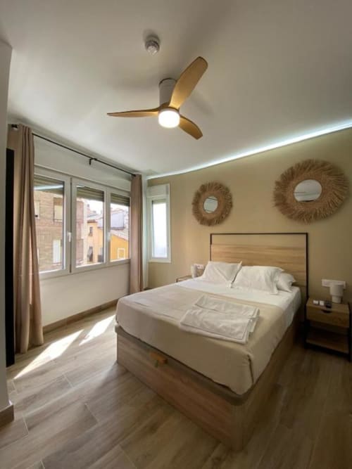 Habitación Bright Superior en Grampy Boutique Hostal con cama de madera, ventilador de techo, ventanas con vista a la ciudad y mobiliario moderno