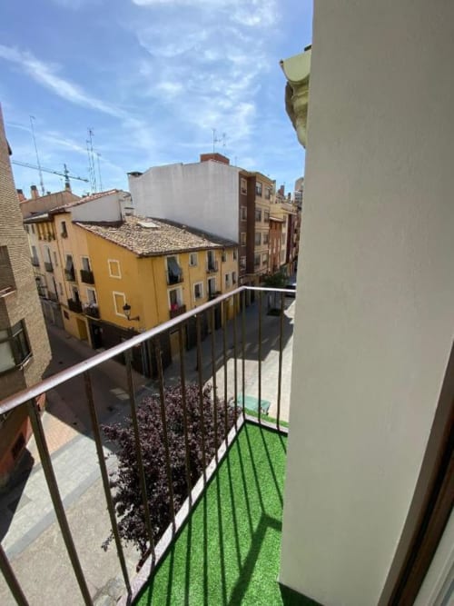 Vista desde el balcón del Grampy Boutique Hostal en España con edificio amarillo y arquitectura medieval