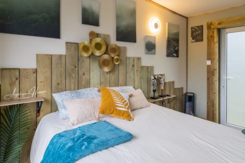 Chambre moderne du gîte Les Rives du bel air avec tête de lit en bois, touches dorées et décoration contemporaine