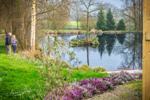Couple savourant les jardins au bord du lac des Rives du Bel Air, gîte de charme en Bourgogne avec bassin réfléchissant