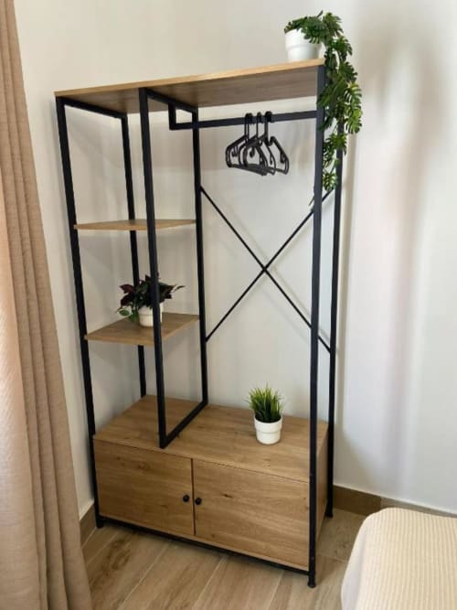 Perchero moderno de metal negro con estantes de madera y almacenamiento en Grampy Boutique Hostal, España