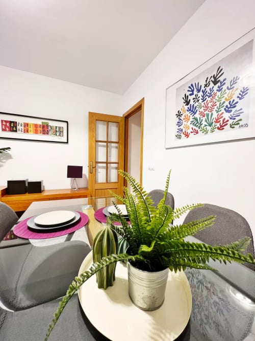 Comedor de moderno apartamento de playa en Fuengirola con decoración costera, plantas en macetas y obras de arte