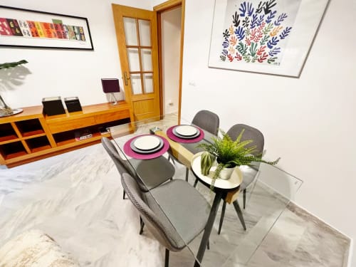 Comedor moderno en apartamento de playa en Fuengirola con sillas grises, mesa de mármol y decoración costera