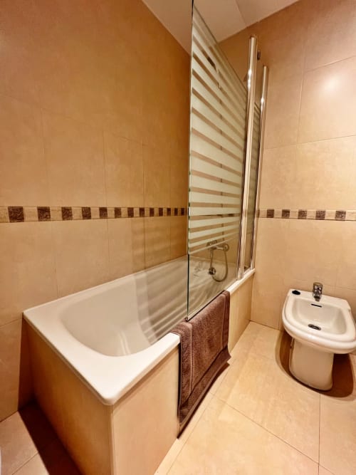 Baño moderno en apartamento de playa en Fuengirola con bañera, mampara de ducha de cristal y bidé