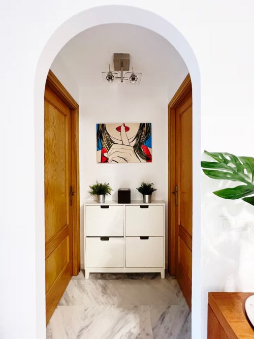 Elegante entrada con arco, puertas de madera, armario blanco y arte moderno en apartamento de playa en Fuengirola