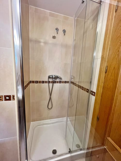 Moderno plato de ducha con azulejos y cenefa decorativa en apartamento de playa en Fuengirola