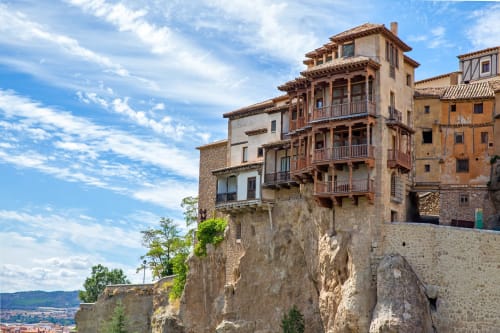Edificios históricos en acantilados de Cuenca, España con arquitectura de piedra y balcones de madera con vistas al paisaje