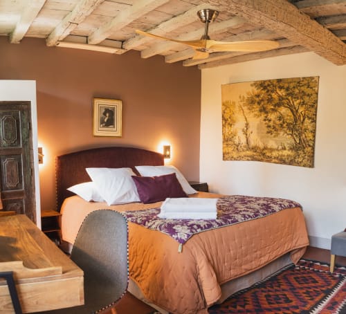 Chambre rustique aux poutres apparentes, murs en terre cuite et décoration traditionnelle aux Jardins de Baracane à Avignon