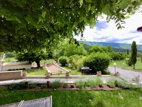 Jardin du Domaine de la Méouge avec terrasses, vue sur les montagnes et pelouses verdoyantes surplombant la campagne française