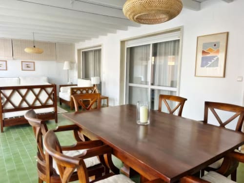 Amplio comedor del apartamento en Fuengirola con muebles de madera, suelo de azulejos verdes y acceso a terraza