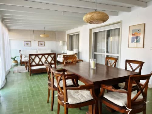 Espacioso comedor del apartamento en Fuengirola con sillas de madera, mesa oscura, lámpara colgante tejida y vista al dormitorio
