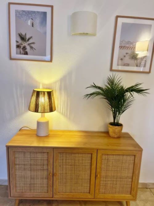 Luminosa esquina de apartamento con mueble de madera, lámpara dorada y planta en Fuengirola