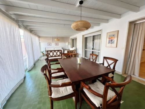 Amplio comedor con mesa y sillas de madera en apartamento de Fuengirola con terraza, techo blanco y suelo verde