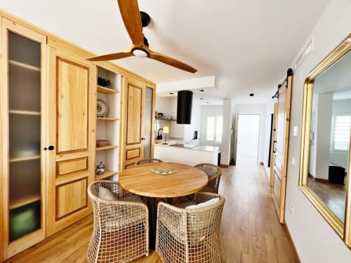 Comedor de apartamento moderno frente al mar con mesa de madera, sillas de mimbre y vistas al océano en Fuengirola