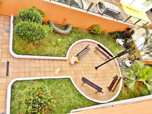 Vista aérea del patio de apartamentos en Fuengirola con zonas de descanso, plantas verdes y caminos