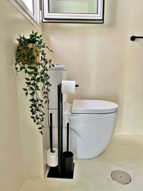 Baño moderno en apartamento de playa en Fuengirola con inodoro, accesorios negros, planta colgante y claraboya