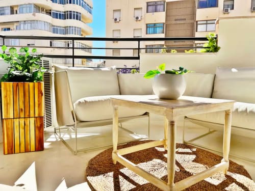 Terraza moderna de apartamento frente al mar en Fuengirola con asientos, mesa de madera y vistas de la ciudad